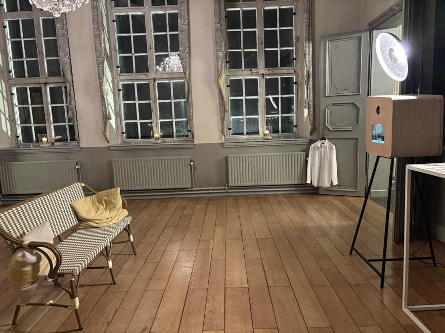 Een kasteelzaal 's avonds met hoge ramen, een bankje en de photobooth in de hoek