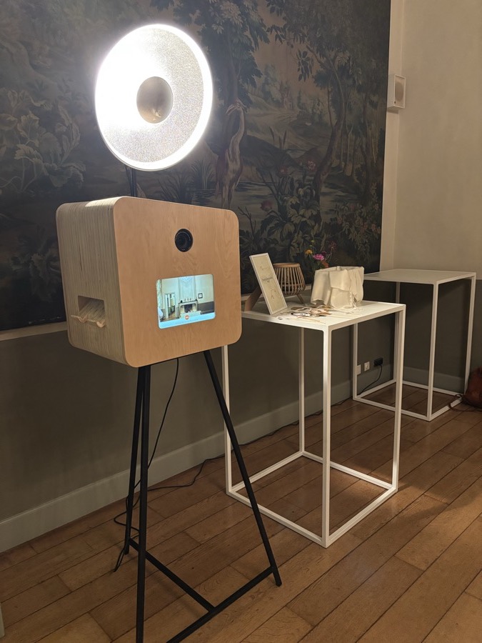 De booth met de lamp aan, naast een witte tafel met een kaartje en een mand
